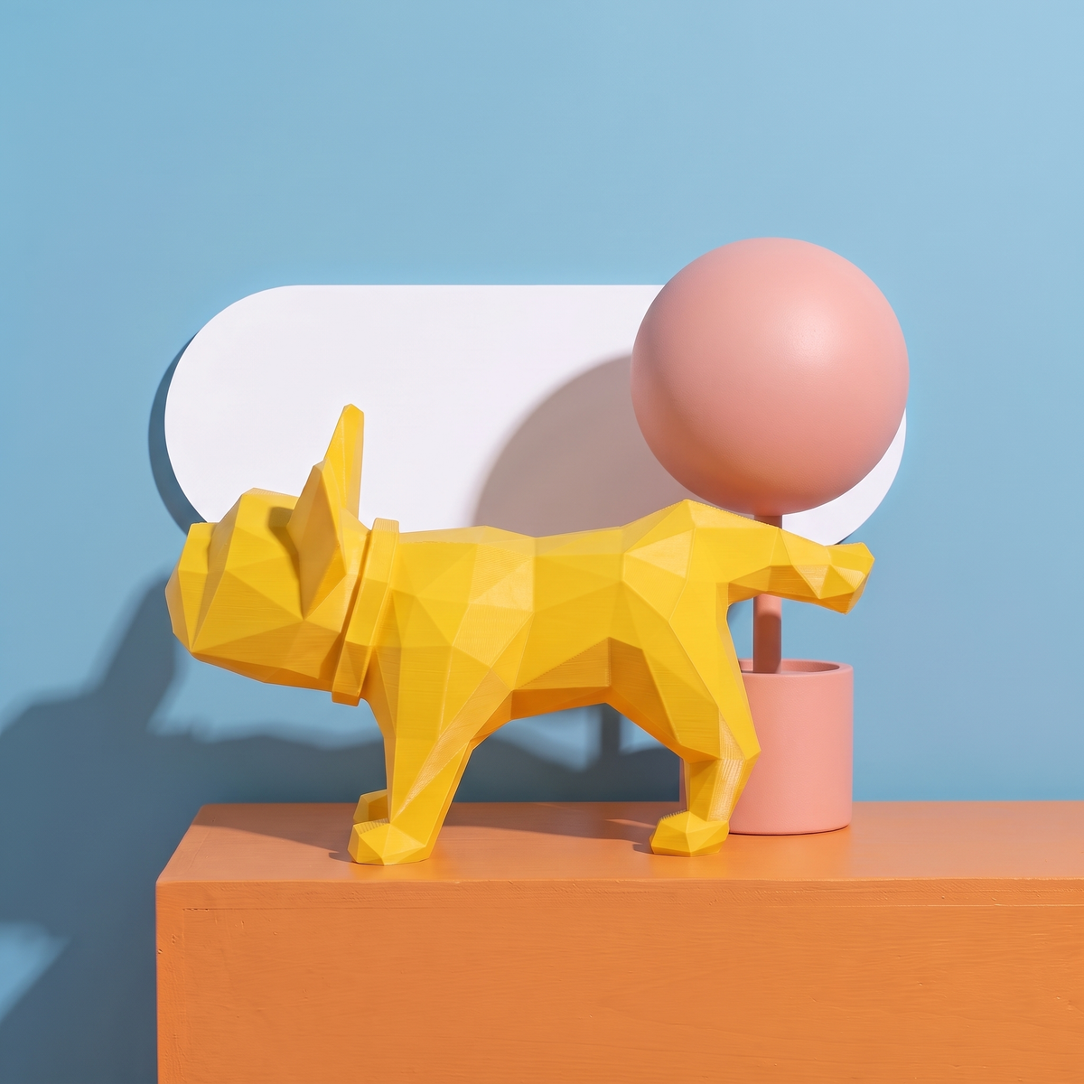 Timmy il Bulldog Francese territoriale giallo, scultura low-poly in bio-PLA stampata in 3D e rifinita a mano, su set color block azzurro